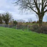 Clipex Horse fence posts in field with netting and top electric wire